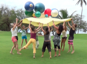 A group of people holding up balloons in the air.